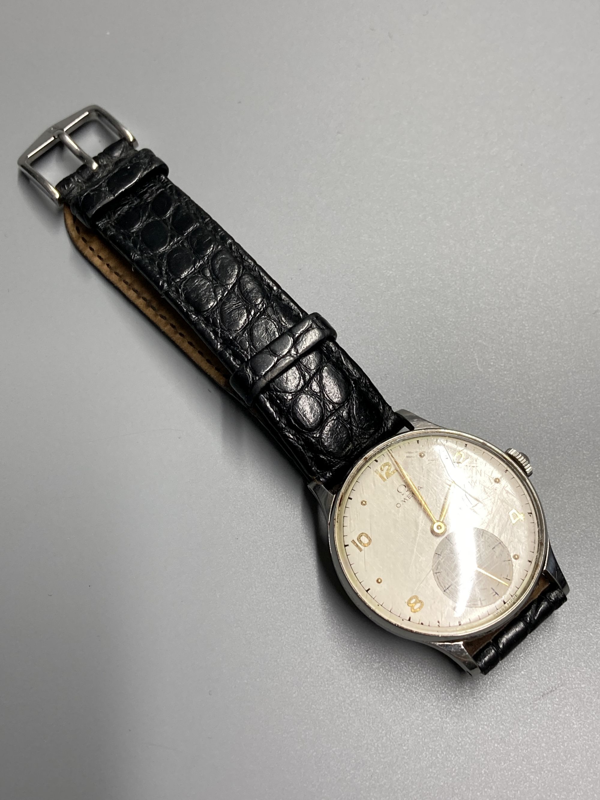 A gentlemans 1940s? stainless steel Omega manual wind wrist watch, with Arabic and dot numerals